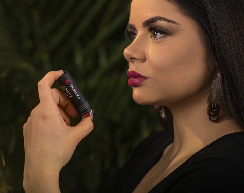 Jenn Harper, Founder and CEO of Cheekbone Beauty Cosmetics, holds a Cheekbone Beauty lipstick.