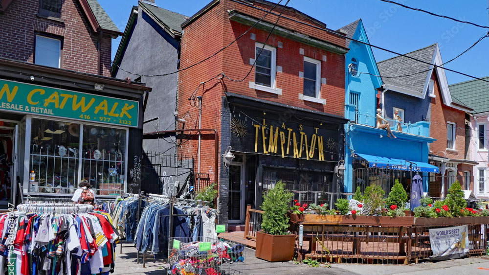 A row of older brick buildings that have been converted into shops and restaurants.